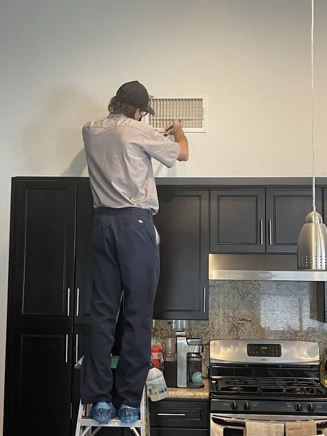 Technician inspecting an air vent during HVAC service in Bridgeton